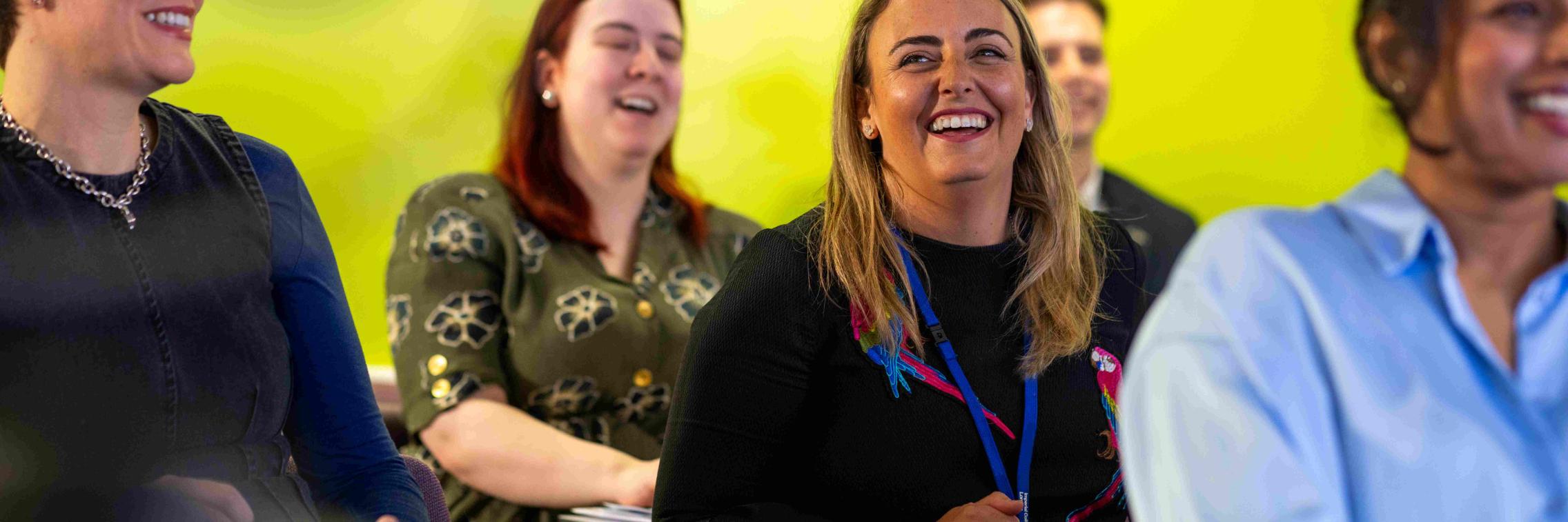 a room of professionals sitting theatre style smiling