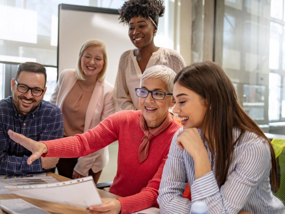 Group of people looking at a computer screen together 